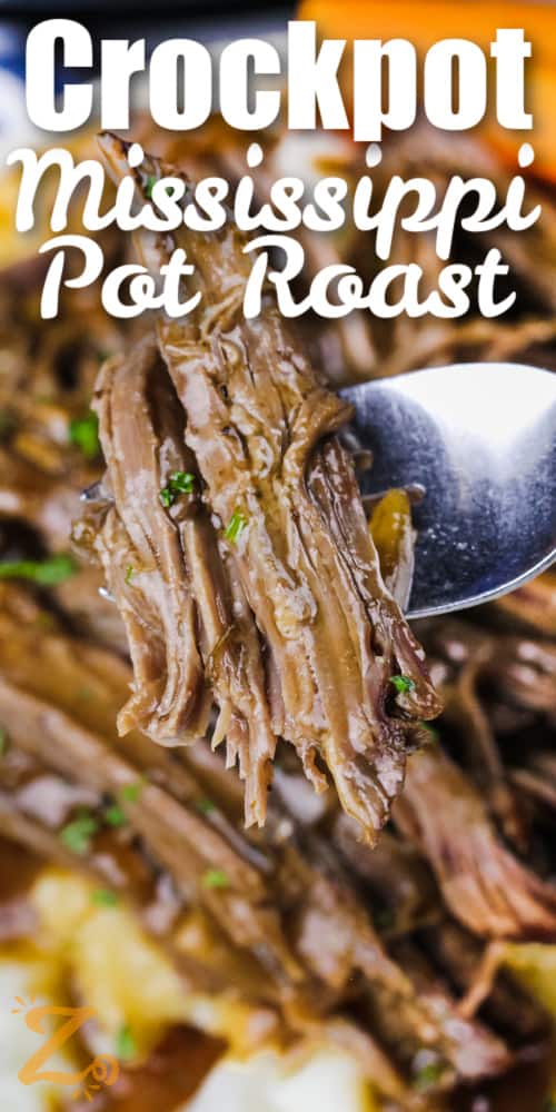 close up of slow cooker Mississippi pot roast on a fork with writing