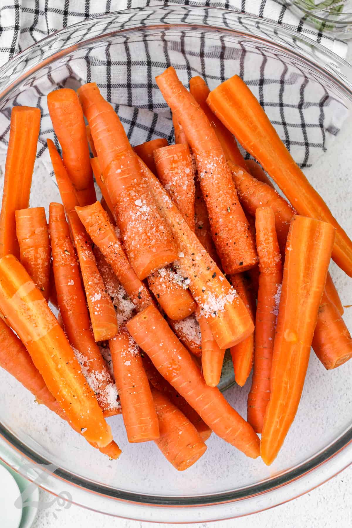 raw carrots in a bowl with oil and salt and pepper for Oven Roasted Carrots