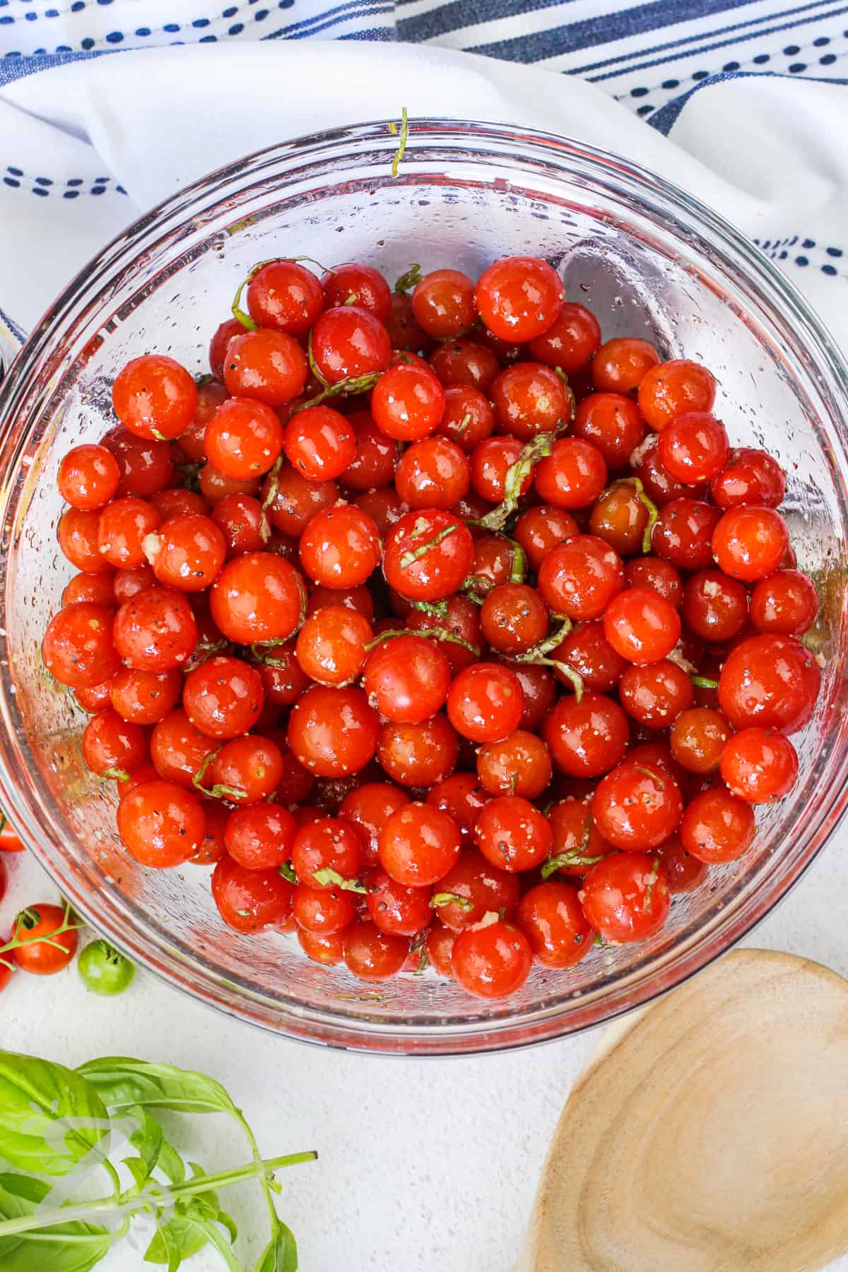 cherry tomatoes mixed with seasonings in a bowl for Roasted Cherry Tomatoes