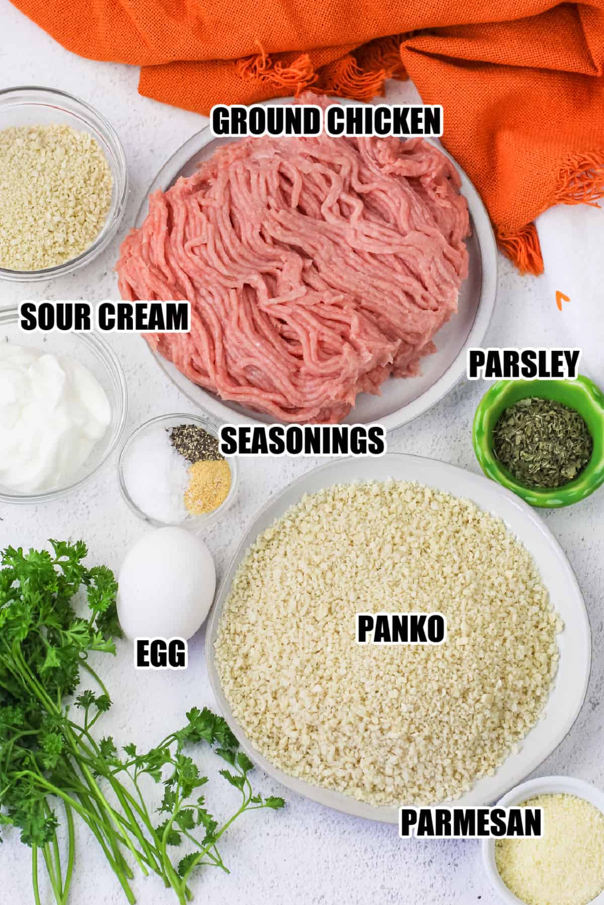 ingredients to make Chicken Nuggets including ground chicken, sour cream, seasonings, parsley, egg, panko, and parmesan