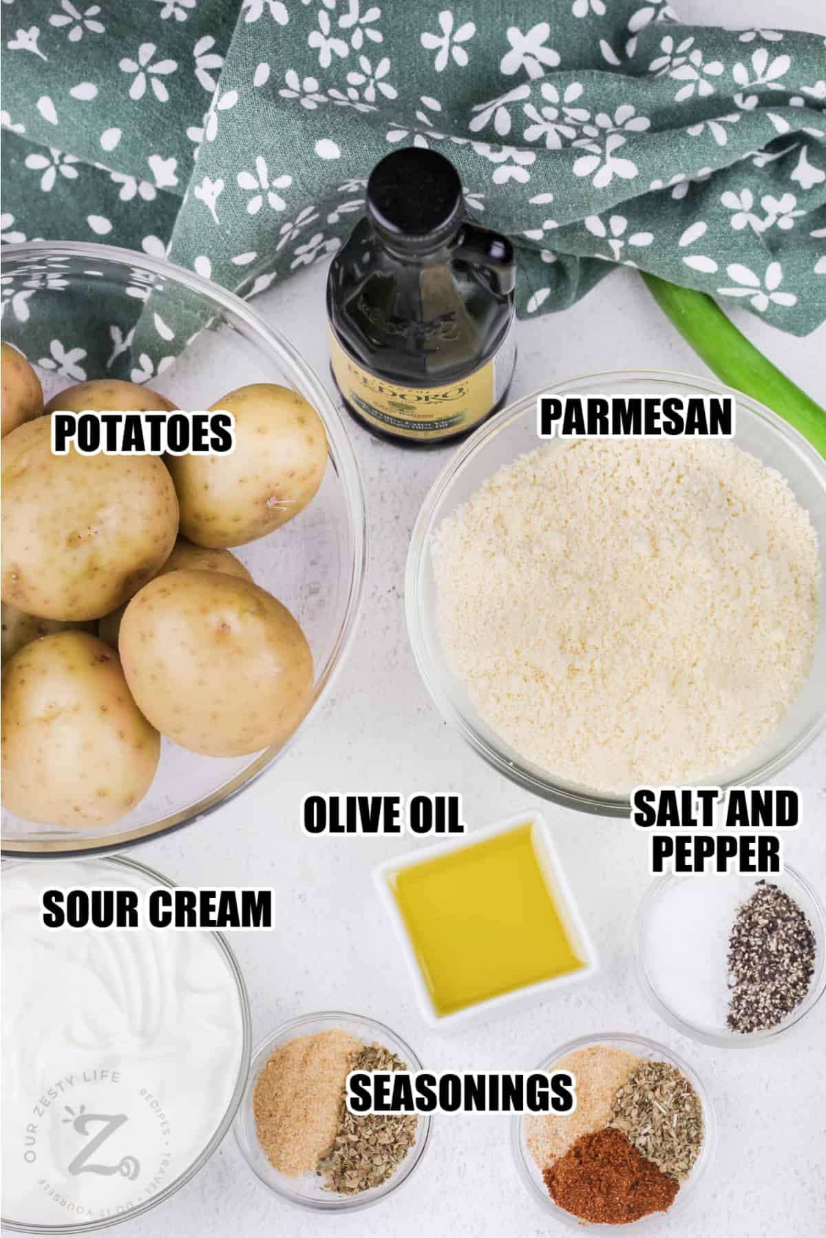 ingredients for Parmesan Roasted Potatoes including parmesan, potatoes, olive oil, salt and pepper, sour cream, and other seasonings
