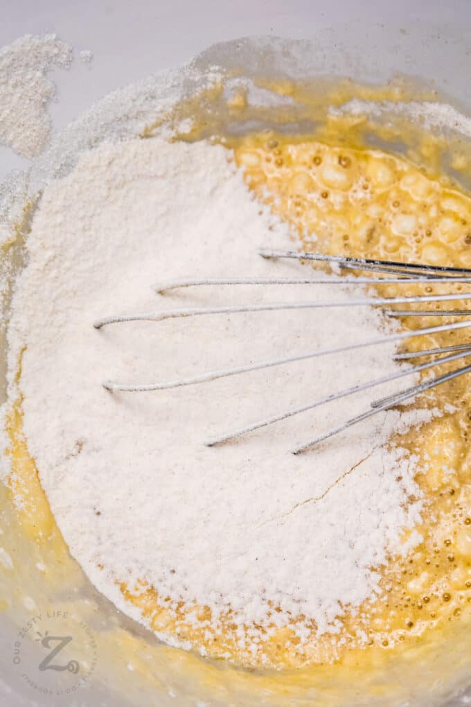 flour being mixed with egg mixture for Pumpkin Cinnamon Rolls