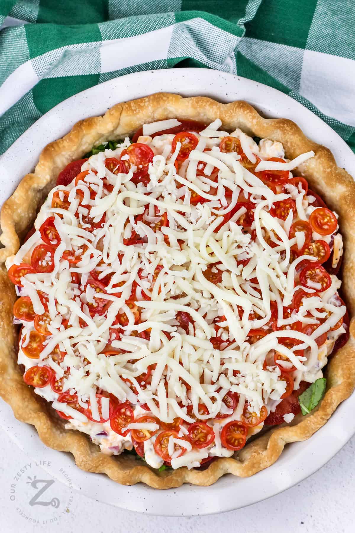 unbaked tomato pie in a white dish