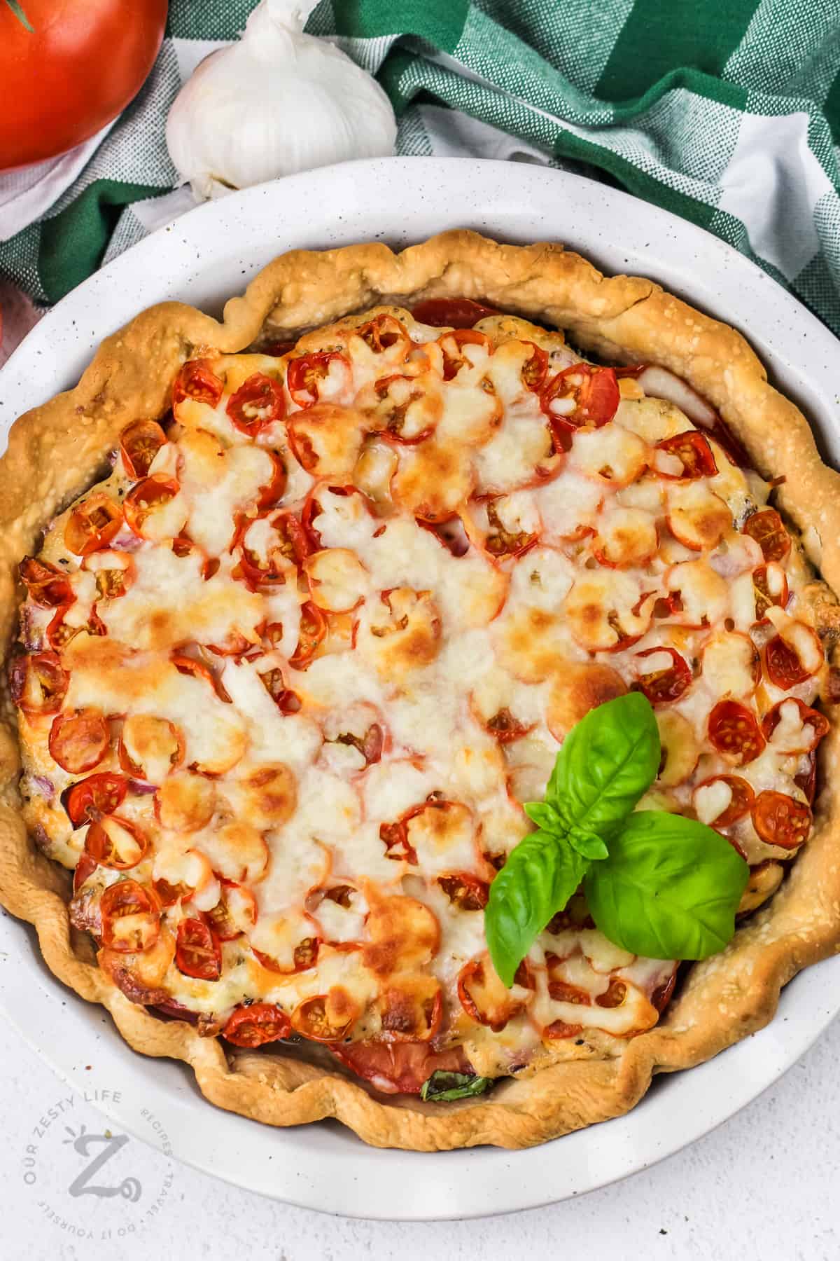 whole tomato pie in a white dish with basil