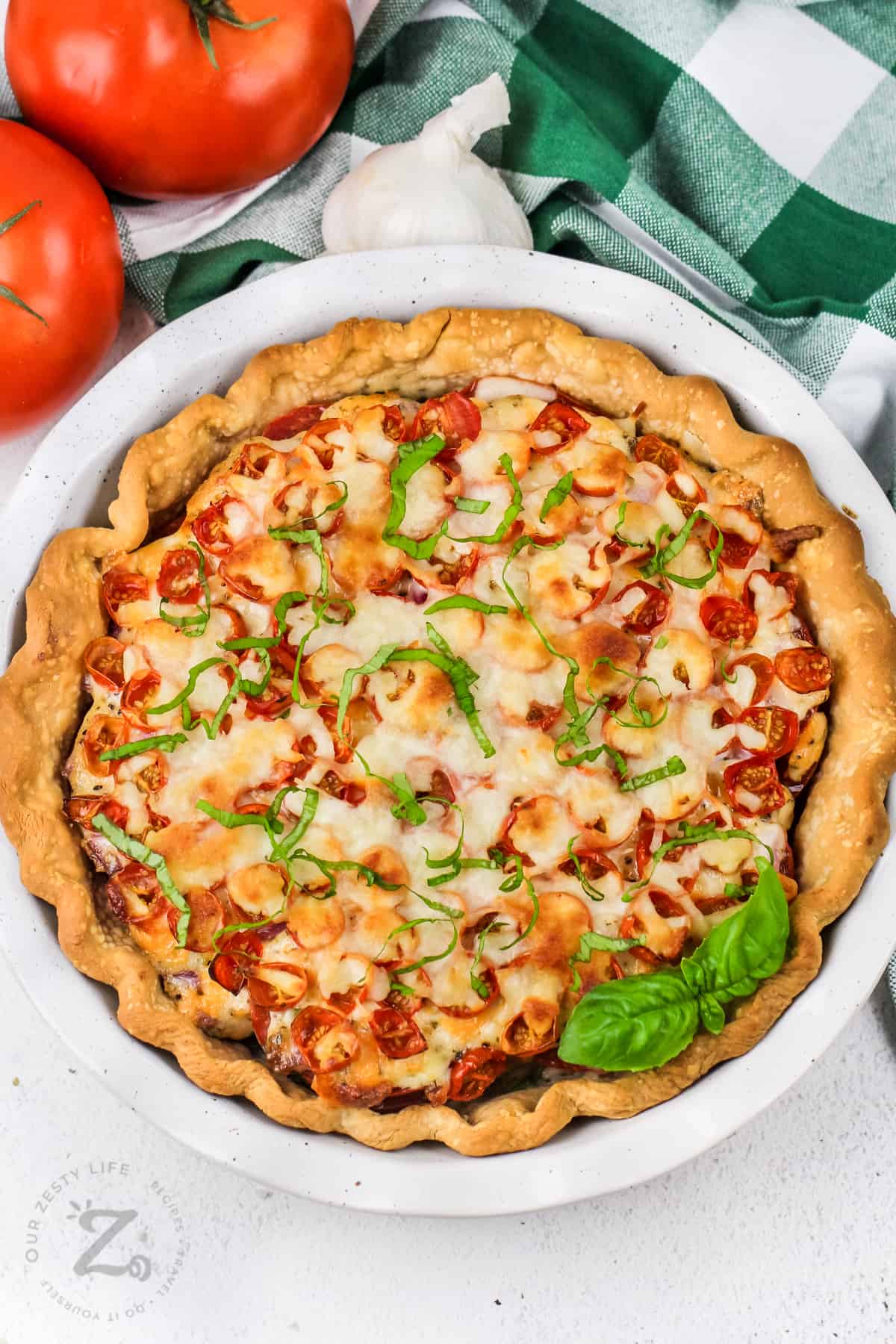 whole tomato pie in a pie dish with basil