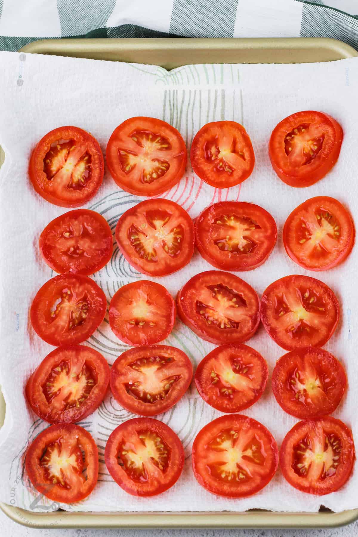 halved tomatoes on a baking sheet for tomato pie