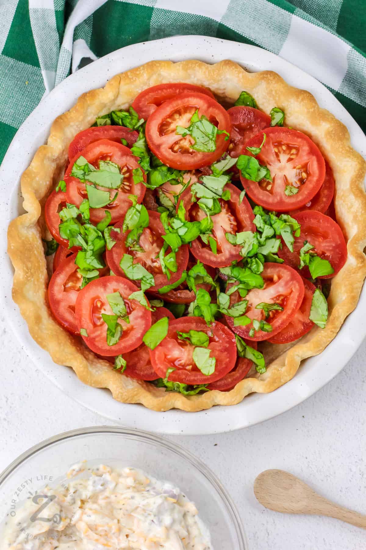 layer of tomato pie in a white dish