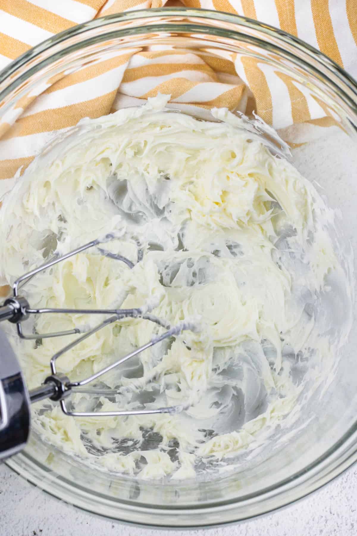whipping butter in a glass bowl for Nanaimo Bars