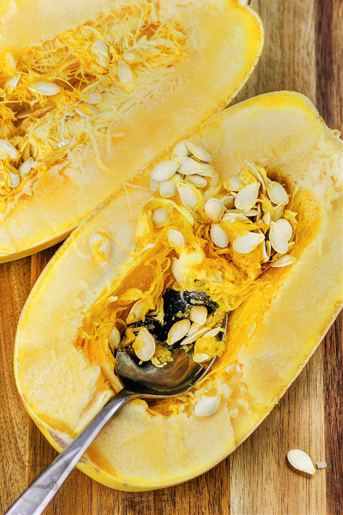 taking the seeds out of a spaghetti squash with a spoon