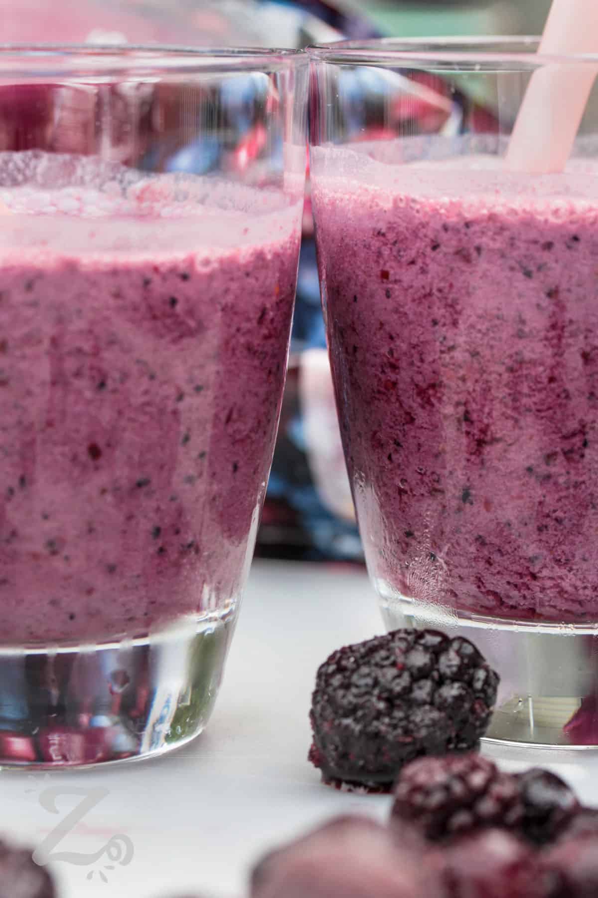 glasses of Mixed Berry Smoothie with berries around it