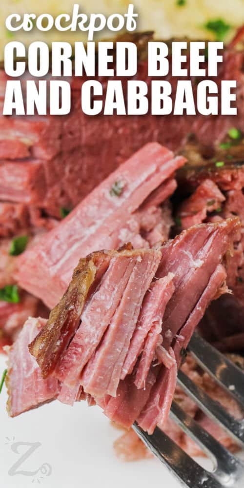 Slow Cooker Corned Beef and Cabbage on a fork with a title