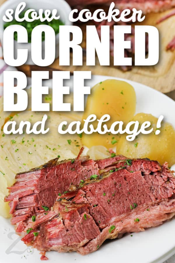 tender Slow Cooker Corned Beef and Cabbage on a plate with writing