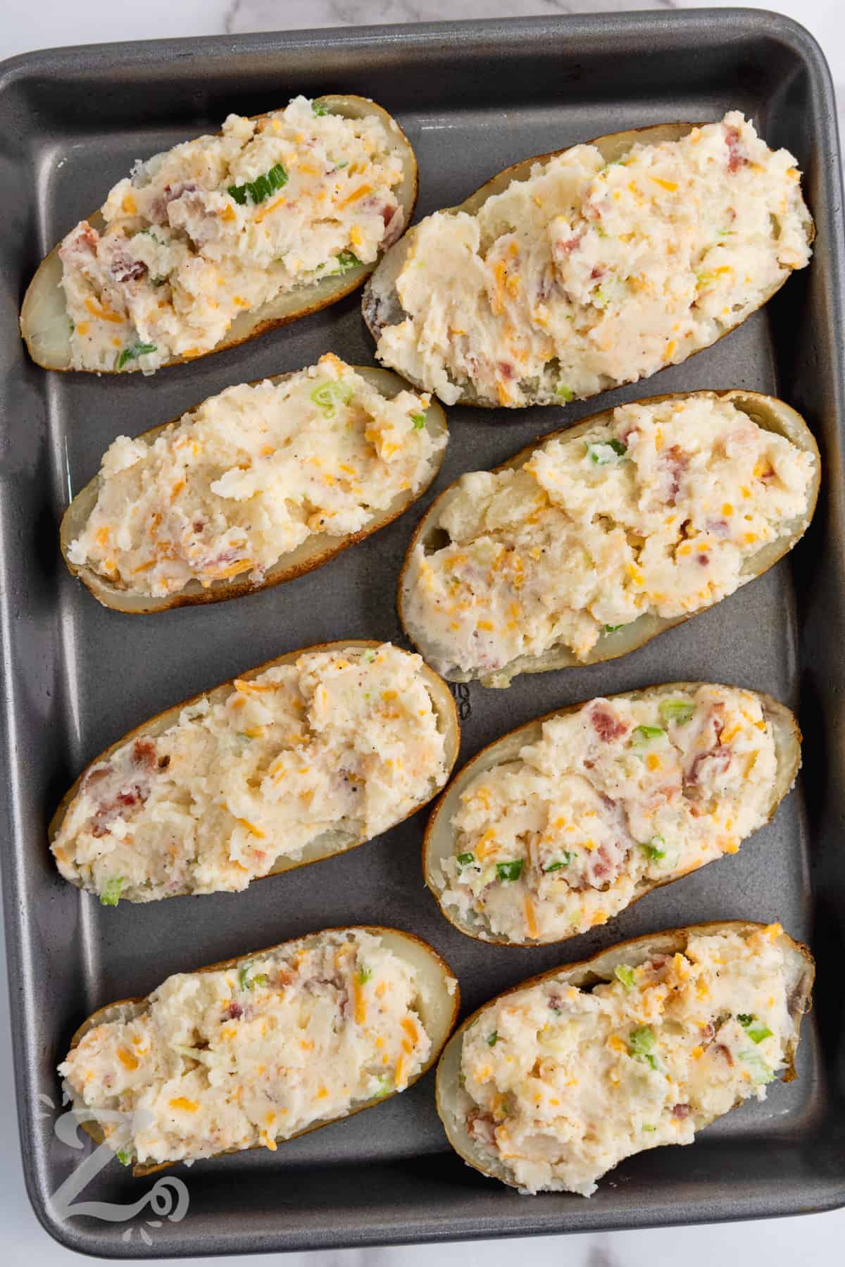 twice baked potatoes stuffed with potato mixture before being baked