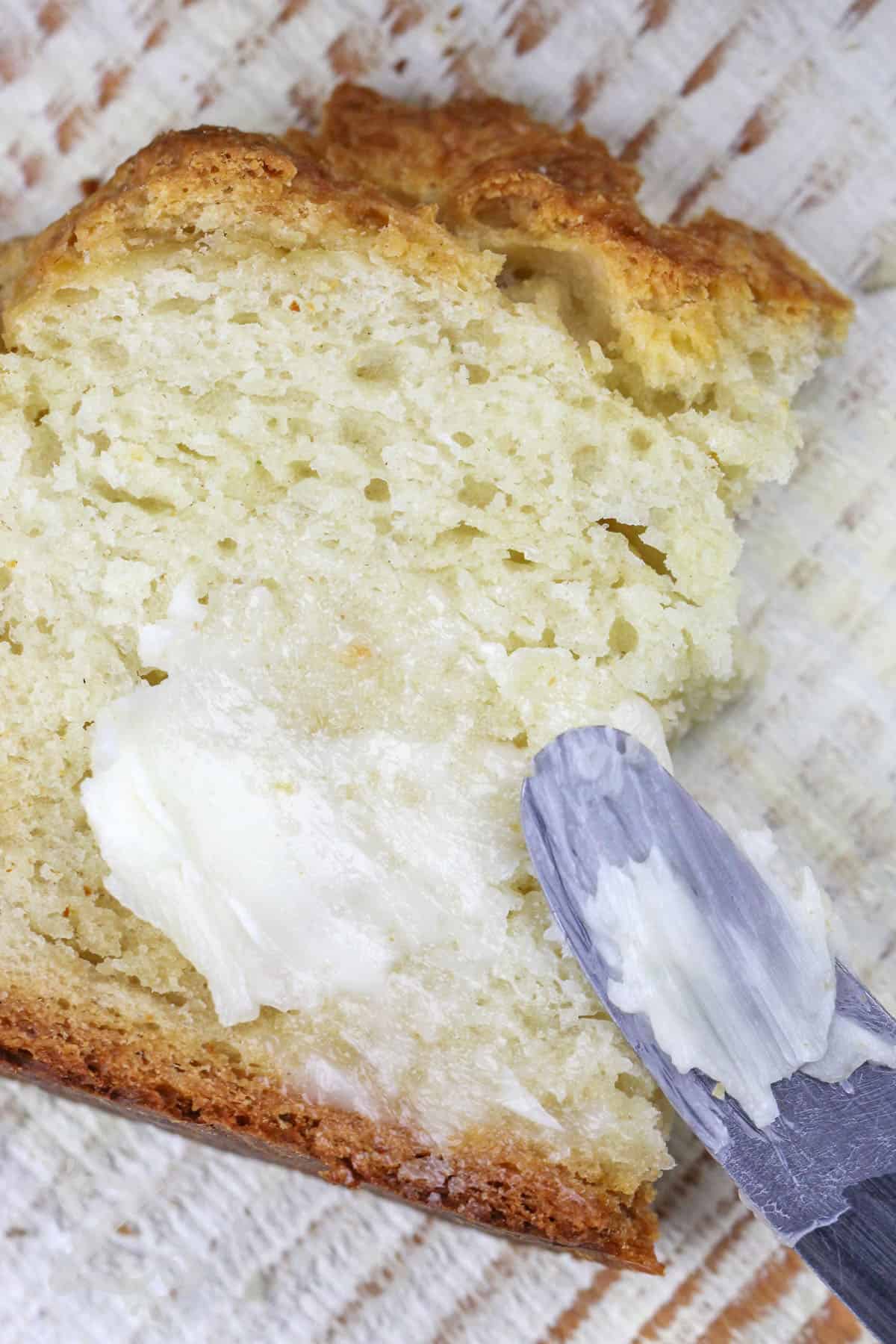 spreading butter on Best Irish Soda Bread Recipe