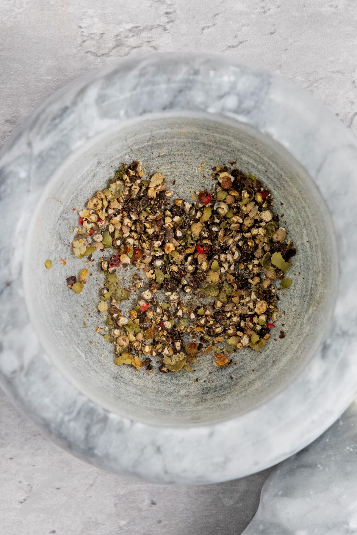 Ground peppercorns in a mortar and pestle.
