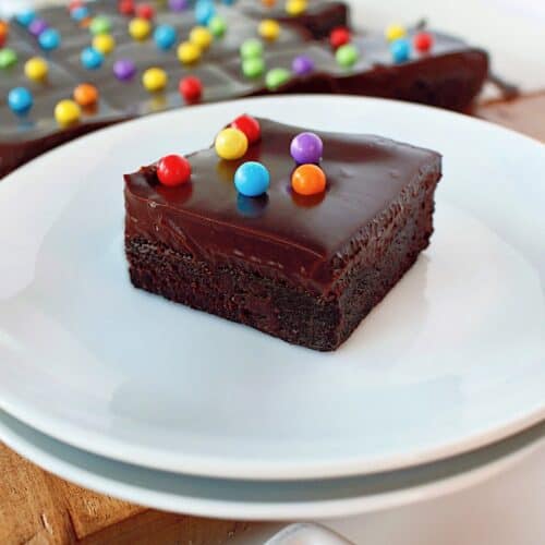cosmic brownie recipe in the background, with one piece on a white plate in the front