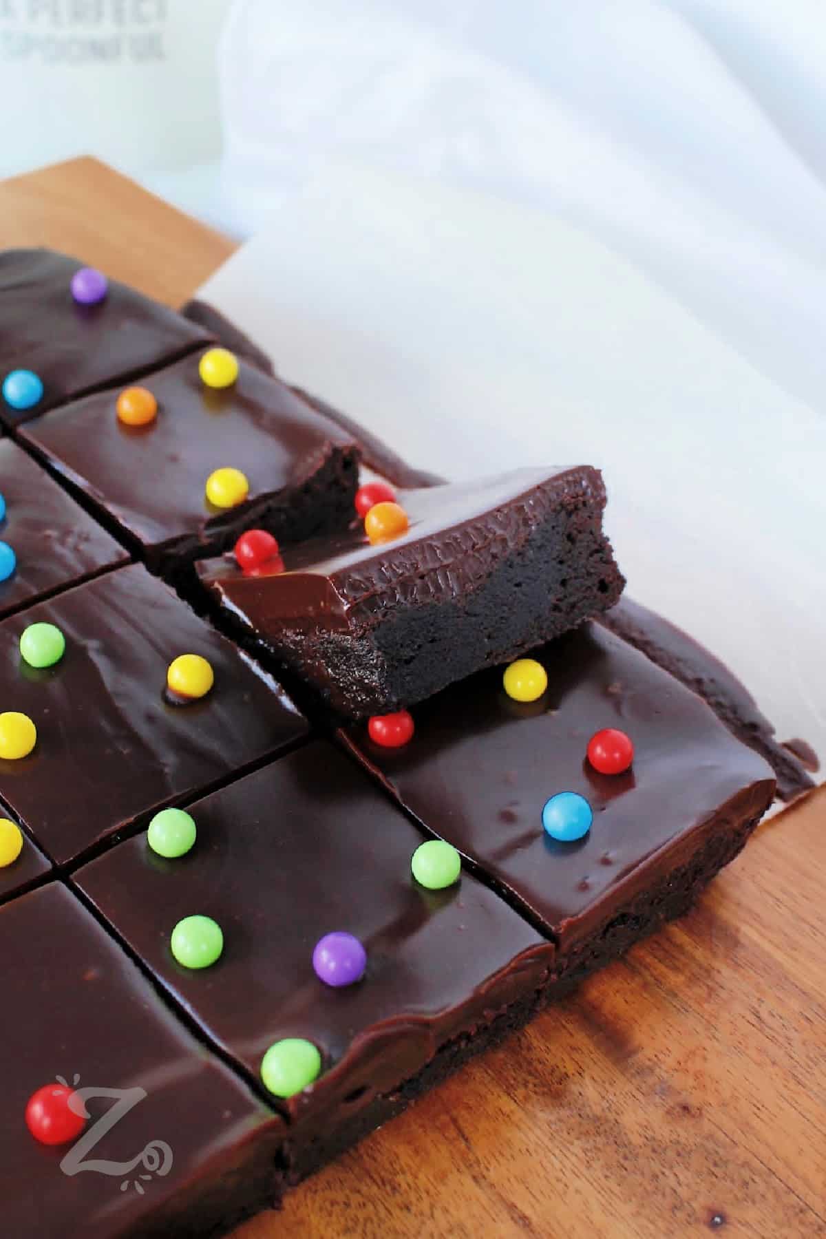 cosmic brownie recipe in parchment paper, with one piece slightly lifted out