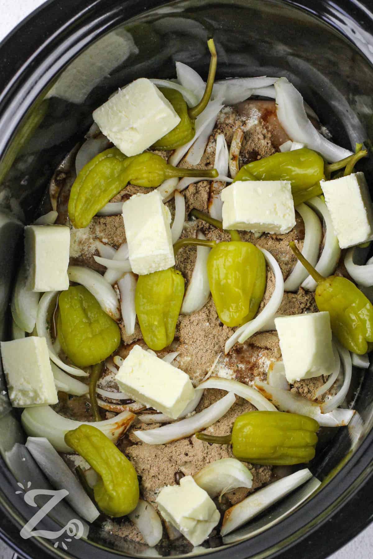 adding butter and jalapeños to crock pot to make Mississippi Chicken