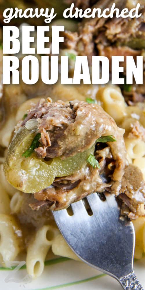Beef Rouladen with macaroni on a fork with writing