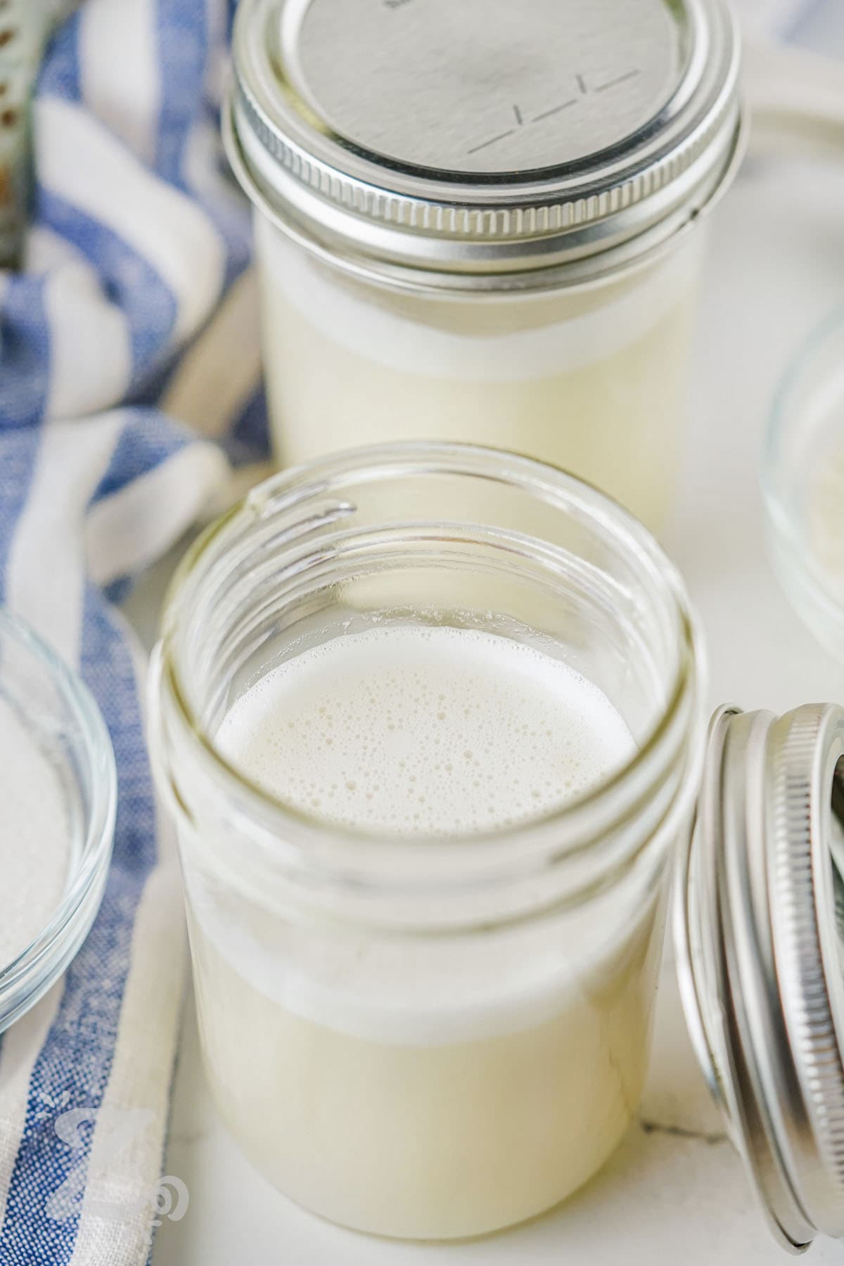 A jar of homemade sweetened condensed milk without a lid on it
