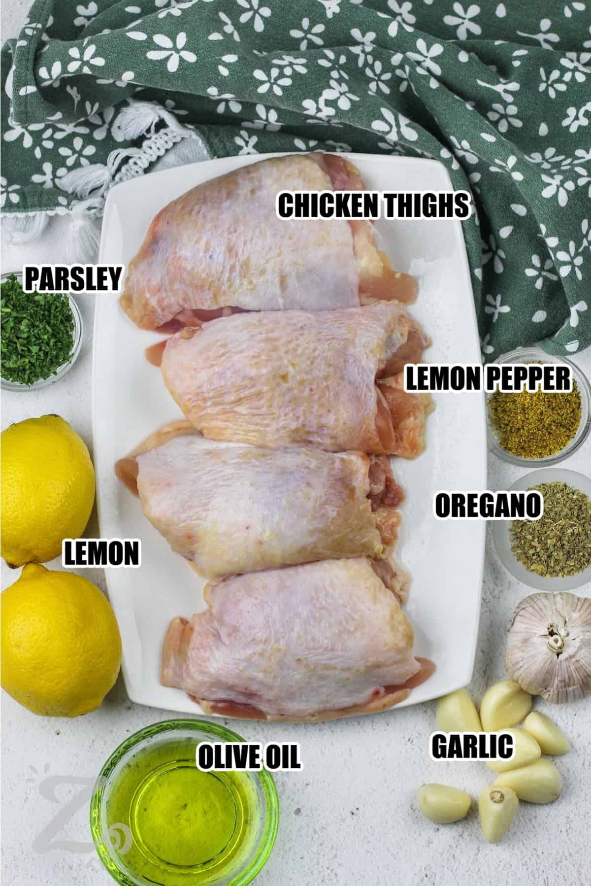 ingredients to make Lemon Pepper Chicken Thighs labeled: chicken thighs, lemon pepper, oregano, parsley, lemon, garlic, and olive oil