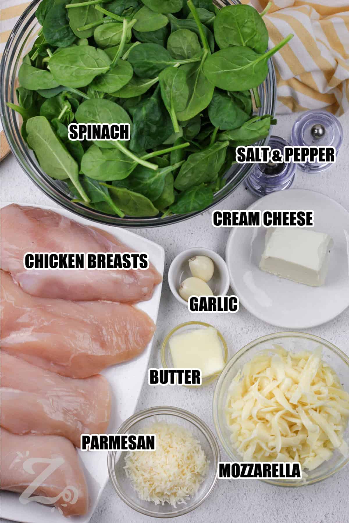 ingredients to spinach stuffed chicken breasts labeled: spinach, salt & pepper, cream cheese, garlic, butter, parmesan, mozzarella, and chicken breasts