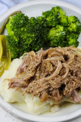 shredded Mississippi Pork Roast served on top of potatoes with broccoli