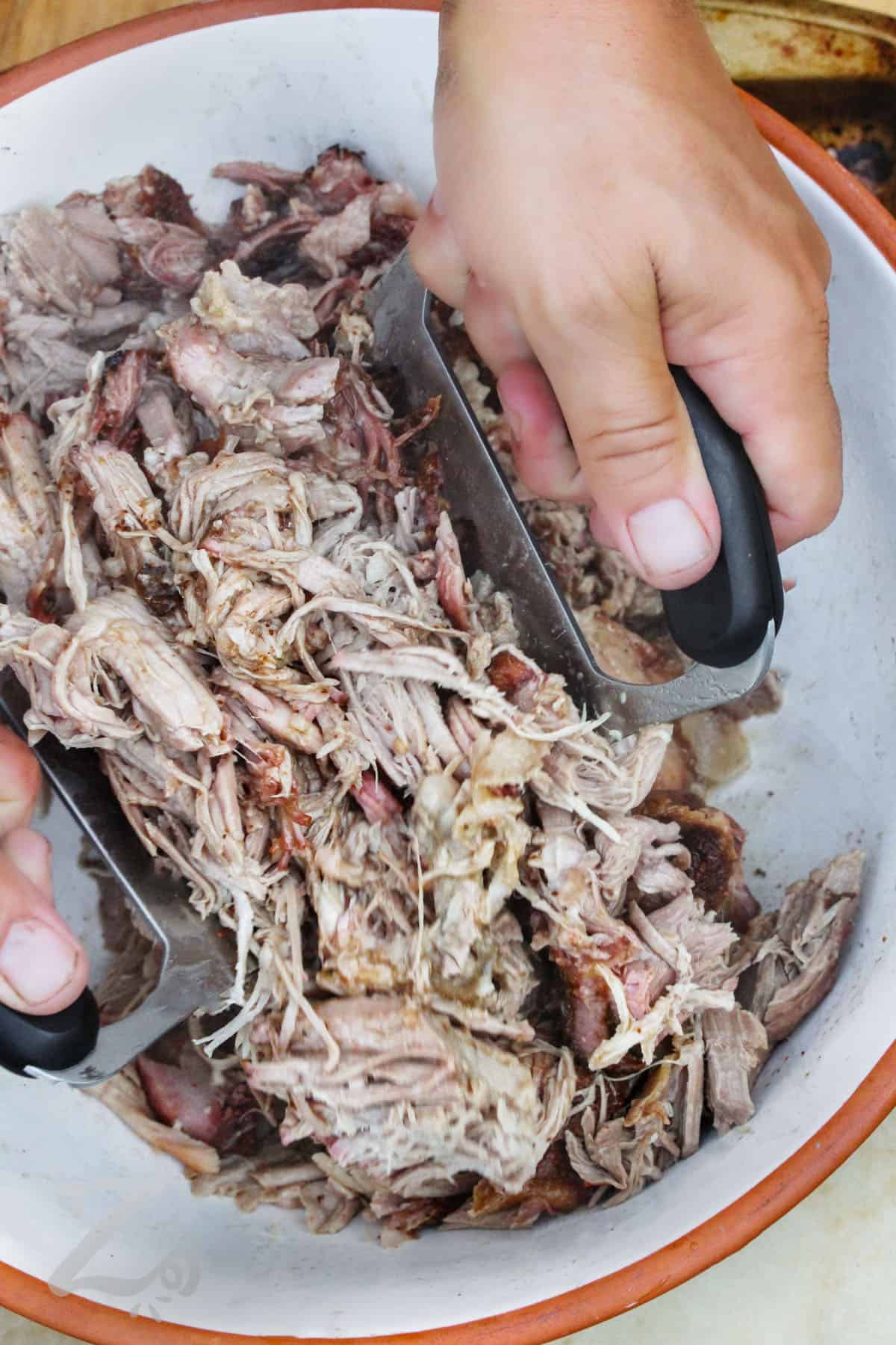 shredding Smoked Pulled Pork in a bowl