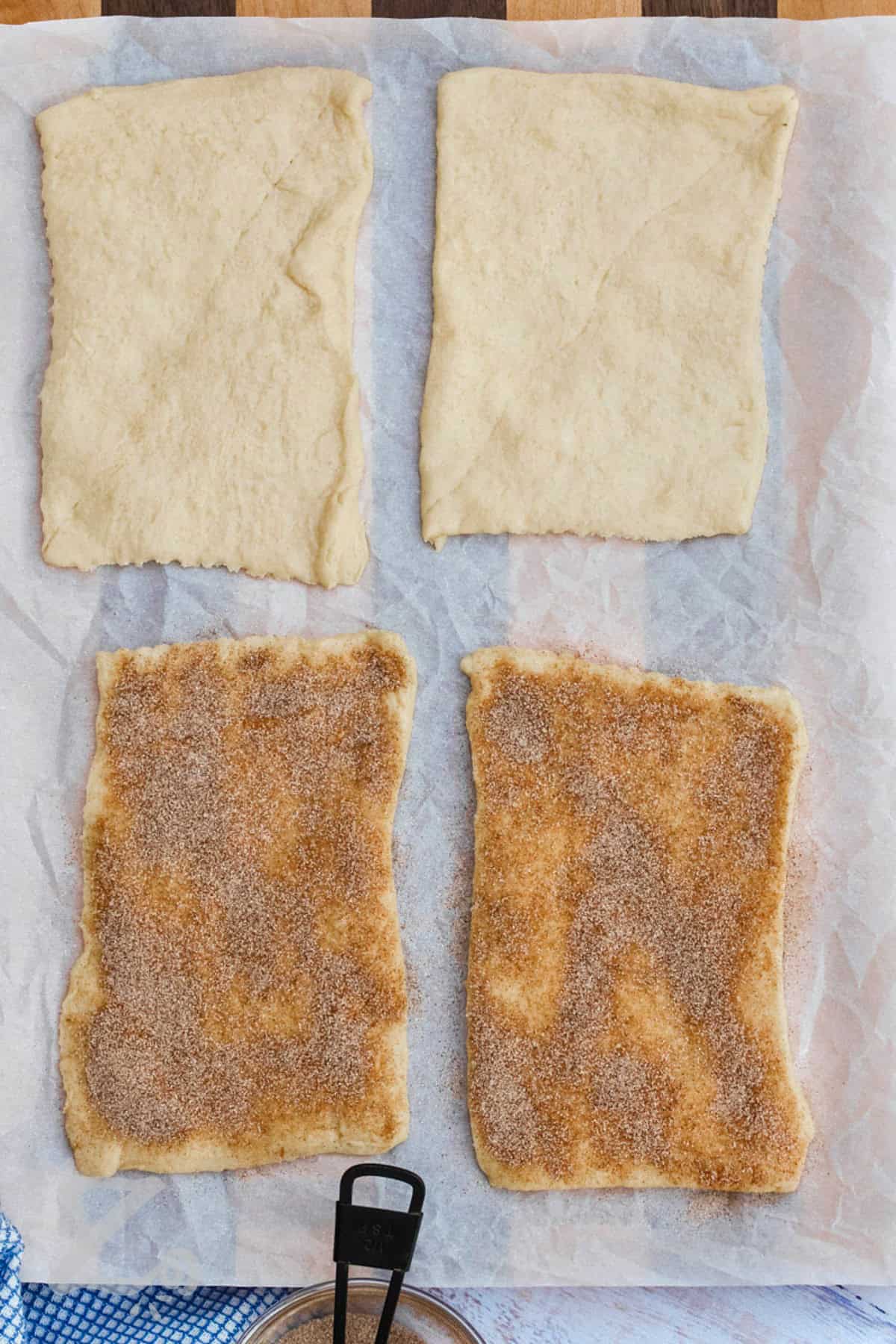 adding cinnamon sugar to pastry sheets to make Baked Churros