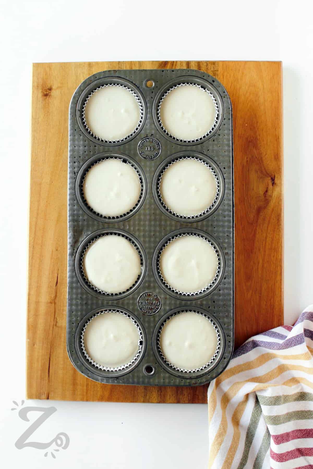 caramel mini cheesecakes in a muffin tin before being baked