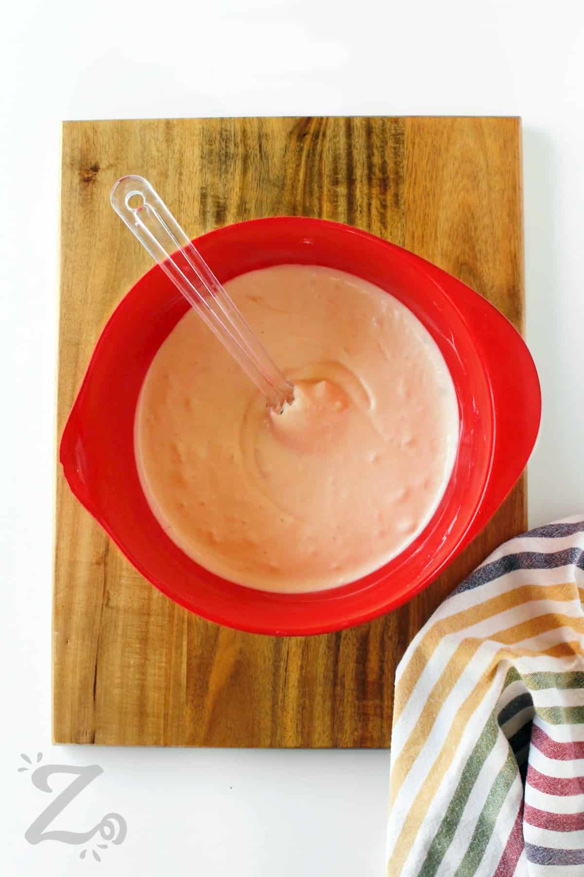 batter for Caramel Mini Cheesecakes in a red bowl