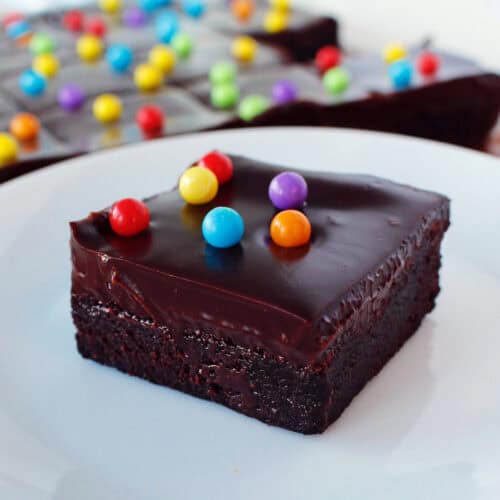 cosmic brownie recipe in the background, with one piece on a white plate in front