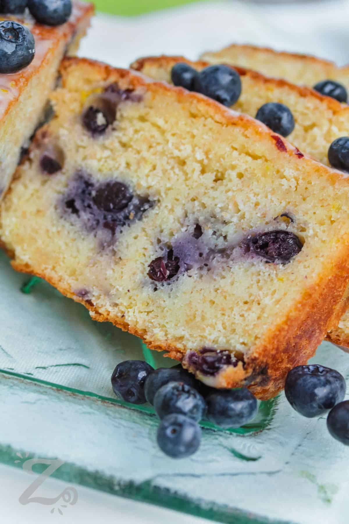 slices of lemon blueberry loaf showing luscious blueberries inside