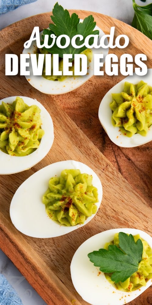 avocado deviled eggs on a serving board with a title