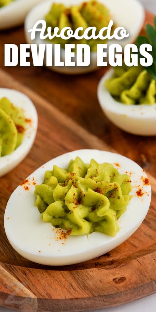 an avocado deviled eggs topped with paprika and a title
