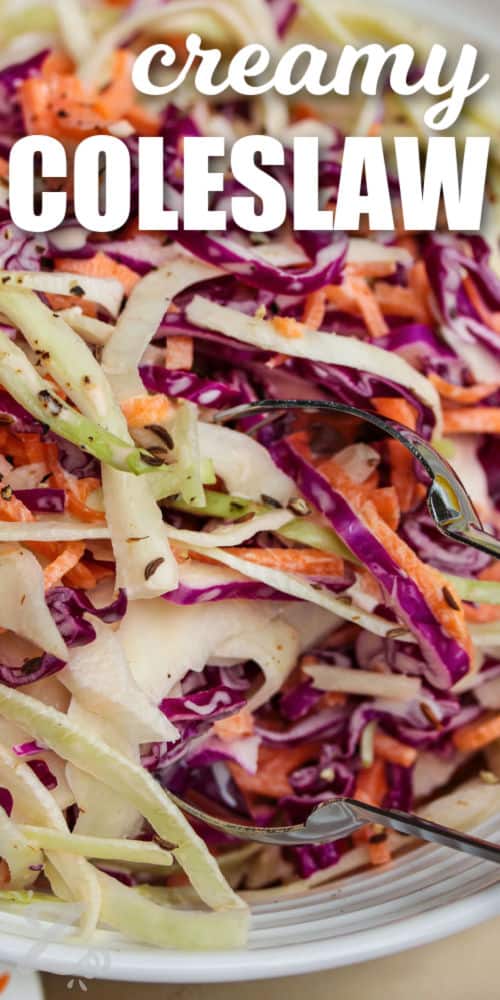 close up of creamy coleslaw in a white bowl with silver tongs, with a title