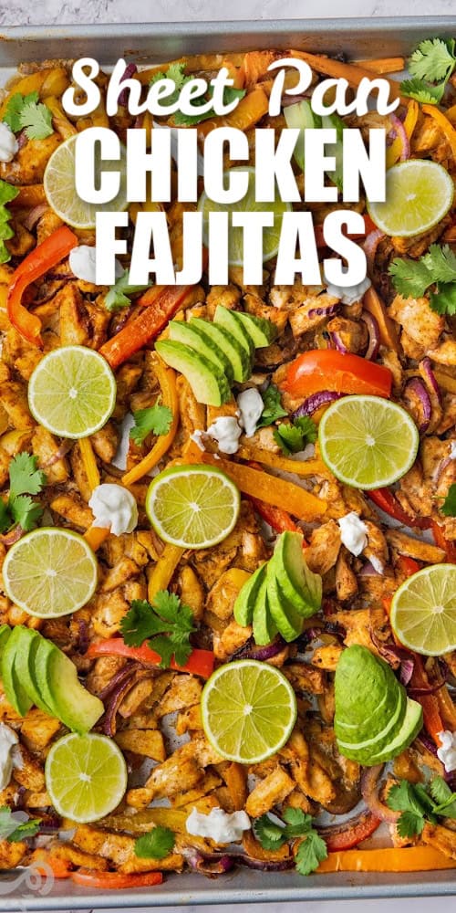 Chicken fajita filling cooked on a sheet pan topped with avocados, lime slices, and cilantro with a title