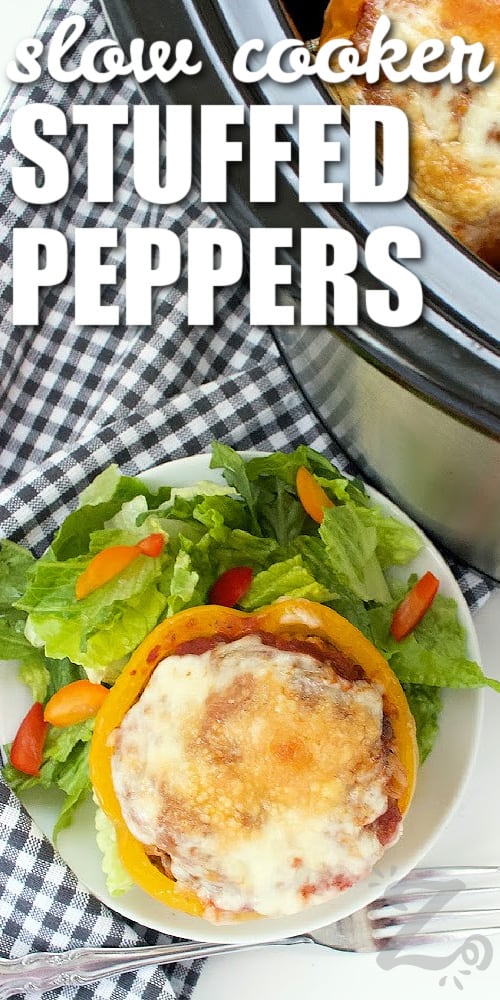 slow cooker stuffed peppers in a crock pot, with one on a white plate with a salad on the side, with a title