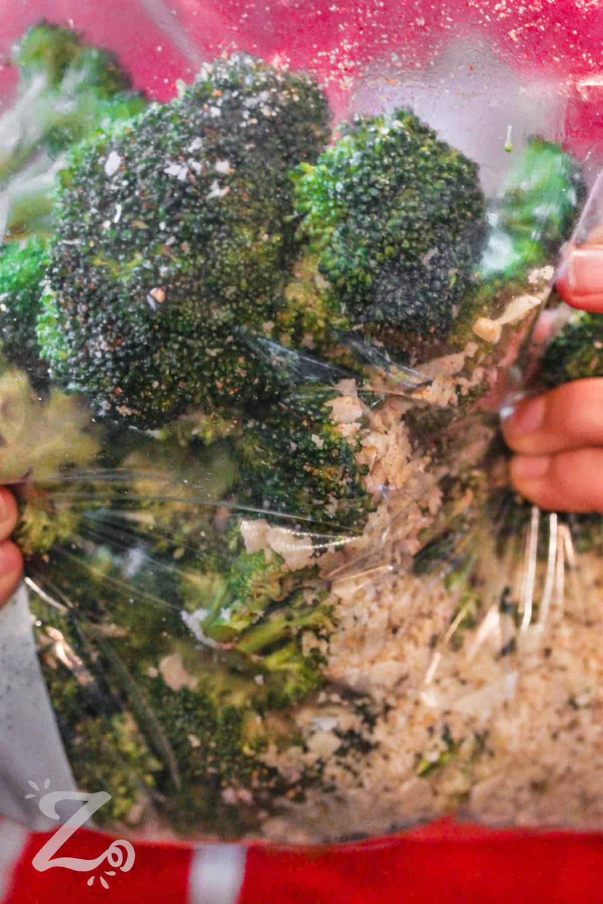 adding parmesan to broccoli in a ziploc bag to make Parmesan Roasted Broccoli