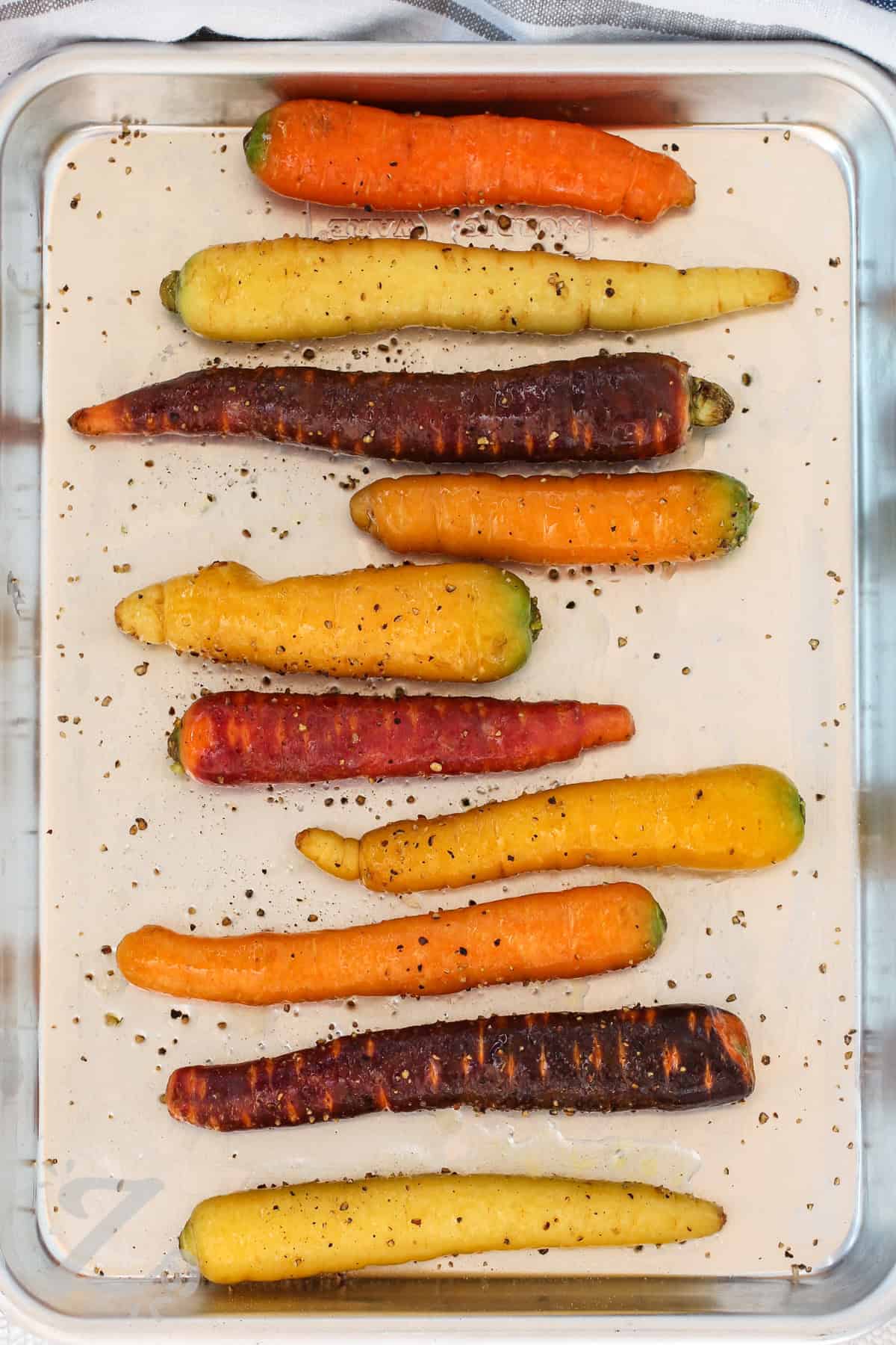 rainbow carrots on a pan with salt and pepper