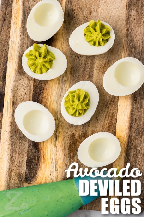 avocado deviled eggs filling being piped into egg whites with a title