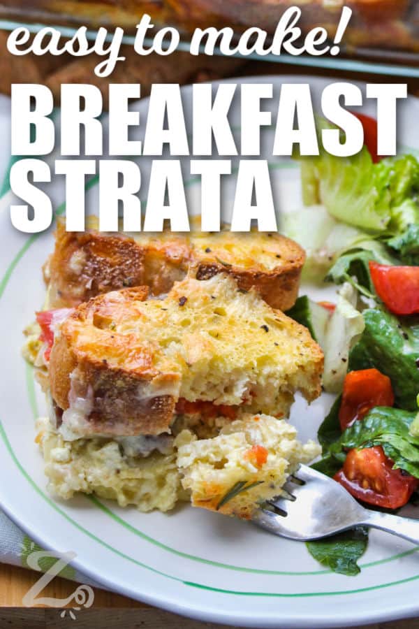 Breakfast strata with sausage, with a fork full of strata on a plate, and a tossed salad on the side with a title