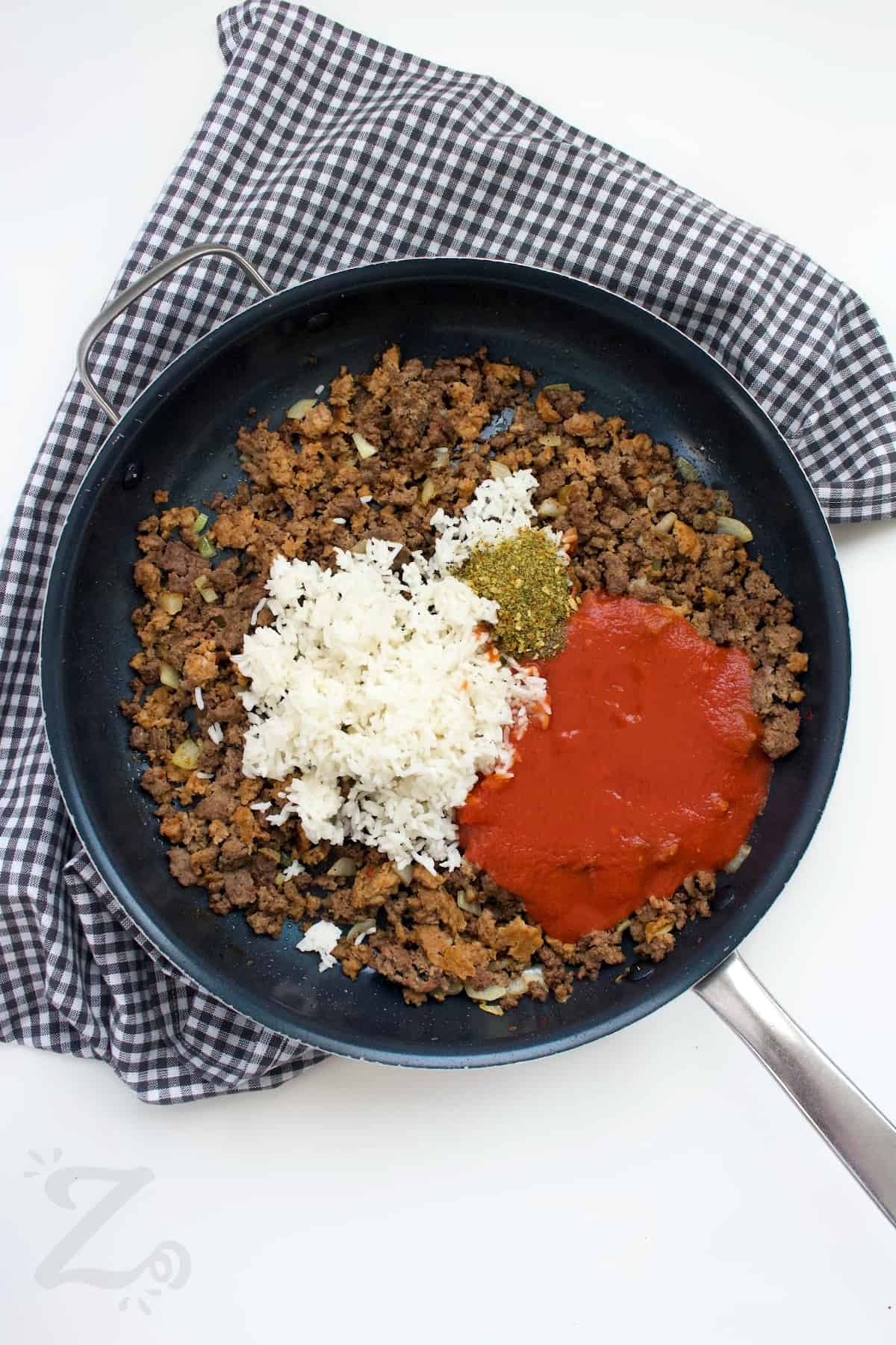 ground turkey and sausage, rice, tomato sauce and seasoning in a skillet to make slow cooker stuffed peppers