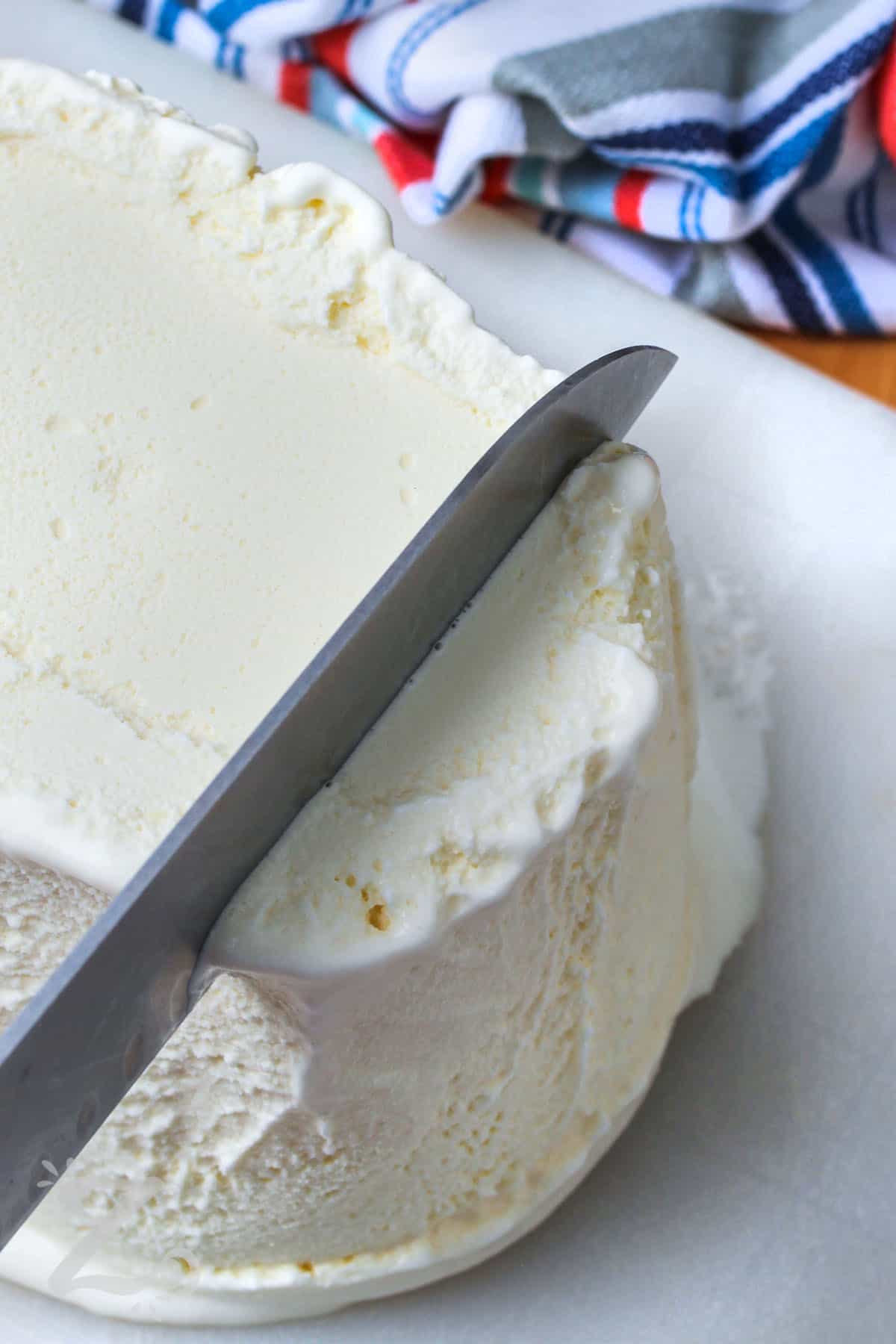 slicing ice cream to make Buster Bar Ice Cream Cake