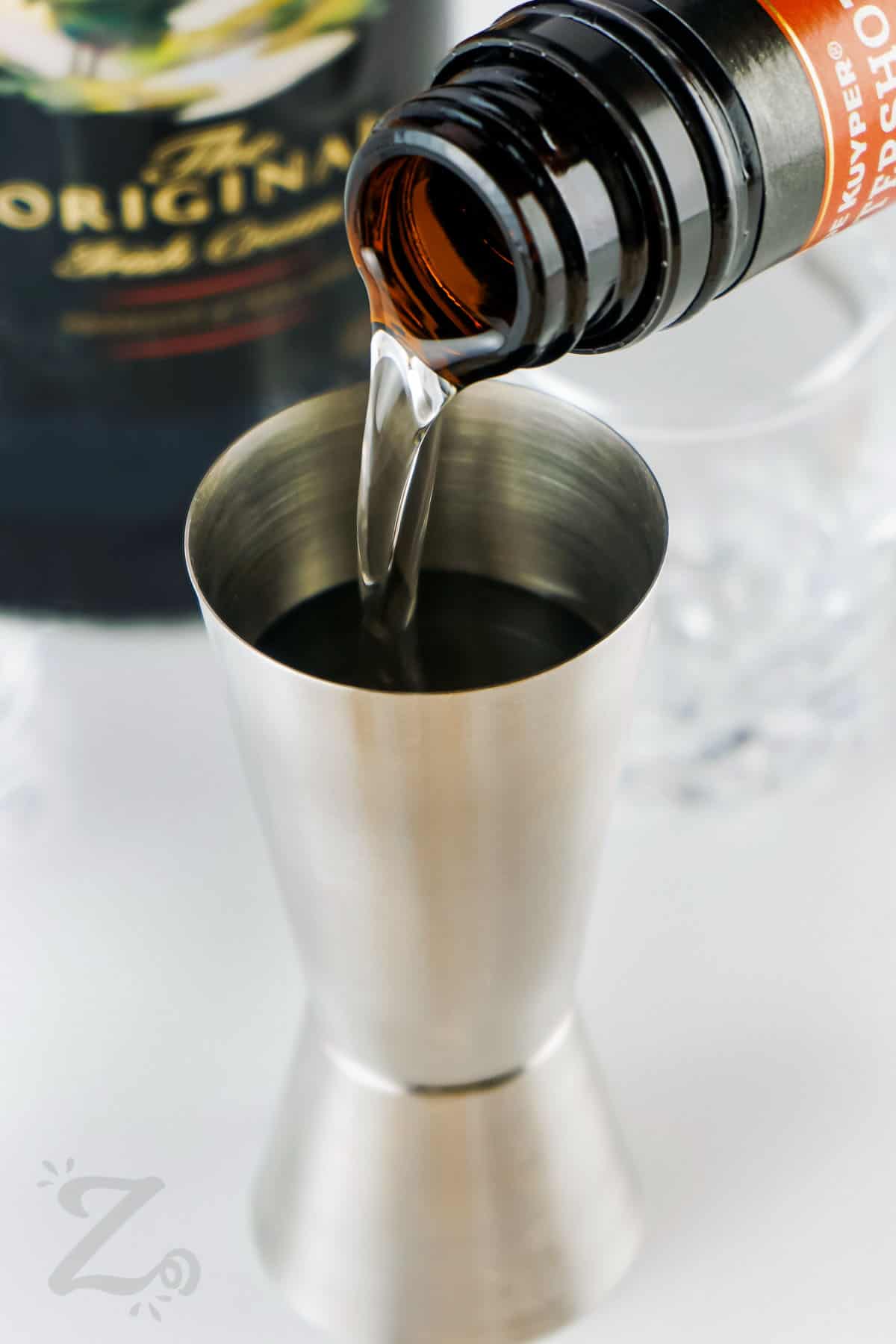 adding butterscotch schnapps to shot glass to make Buttery Nipple Shot