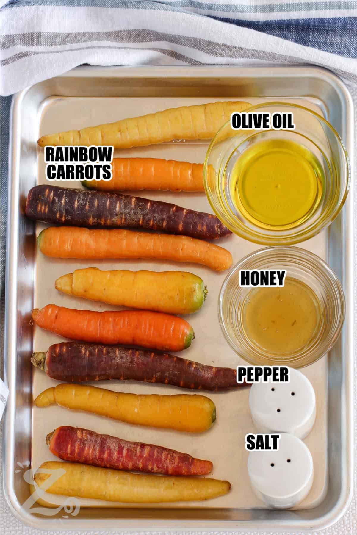 ingredients to make roasted rainbow carrots labelled: rainbow carrots, olive oil, honey, salt and pepper.