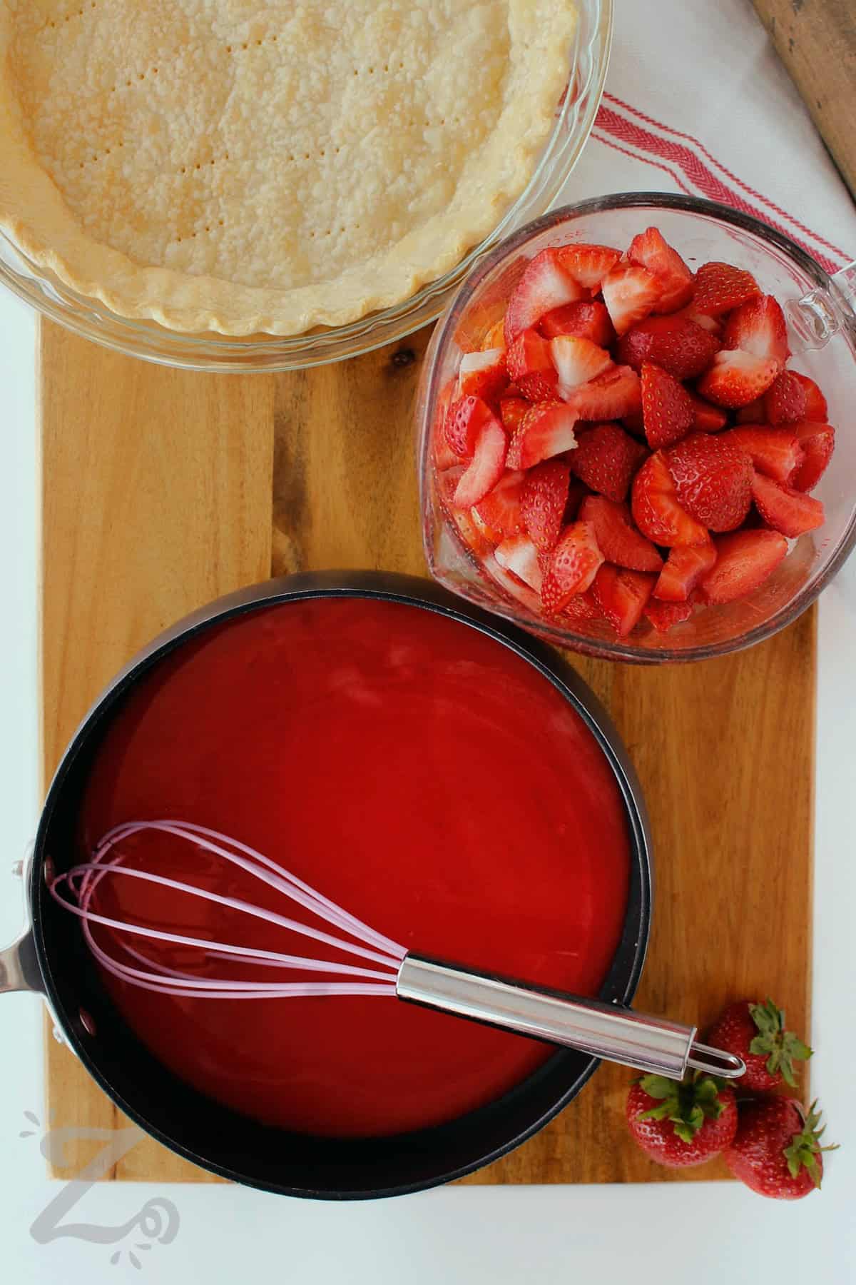 water, sugar, cornstarch and strawberry Jell-o whisked in a pot, with strawberries and baked pie shell on the side, to make Fresh Strawberry Pie