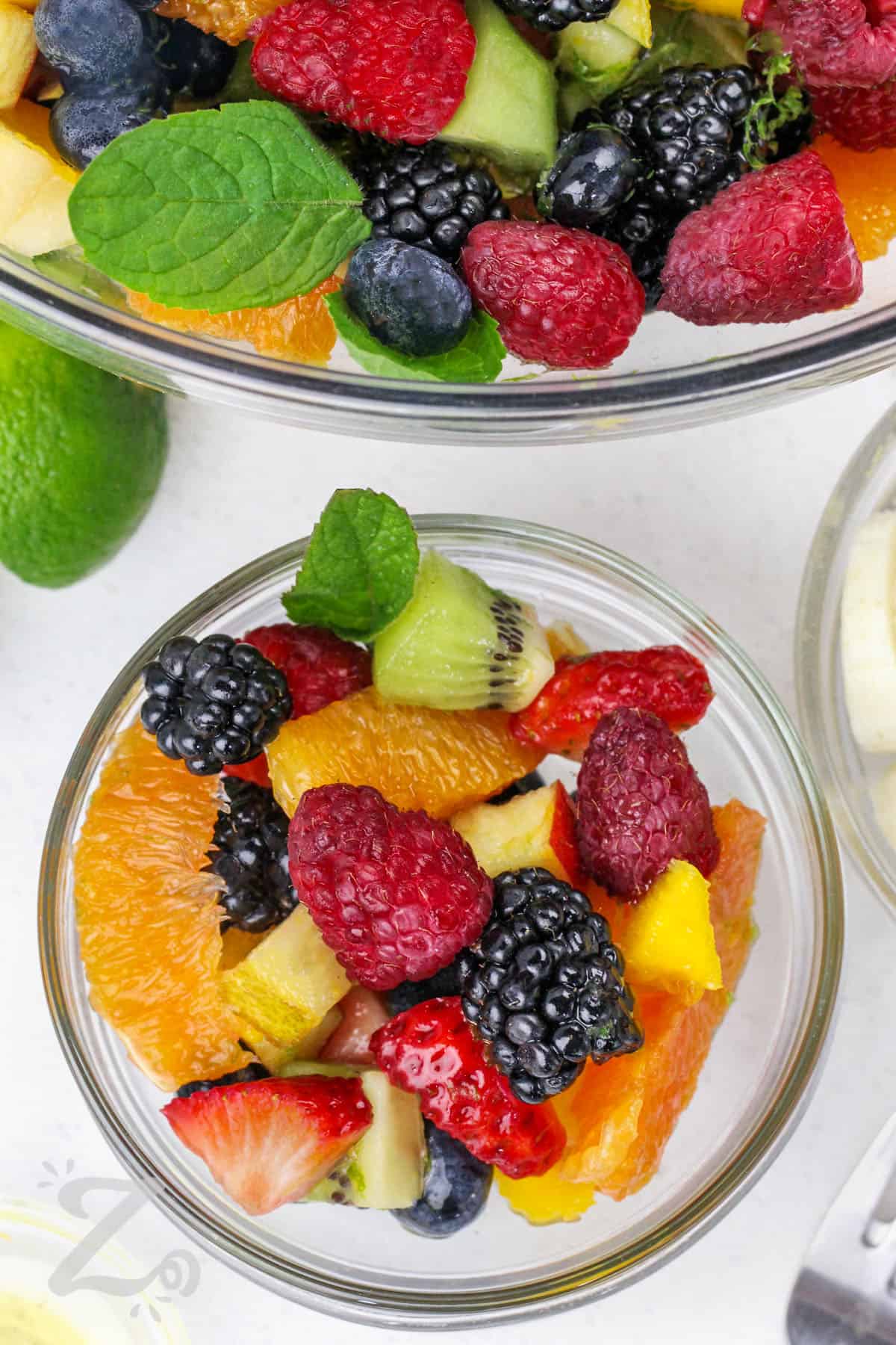 this recipe for fruit salad in a small clear bowl with a large clear bowl on the side is so easy