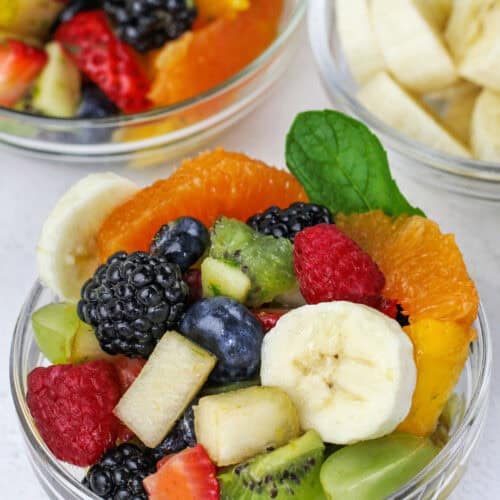 a clear bowl holds a serving of an easy recipe for fruit salad