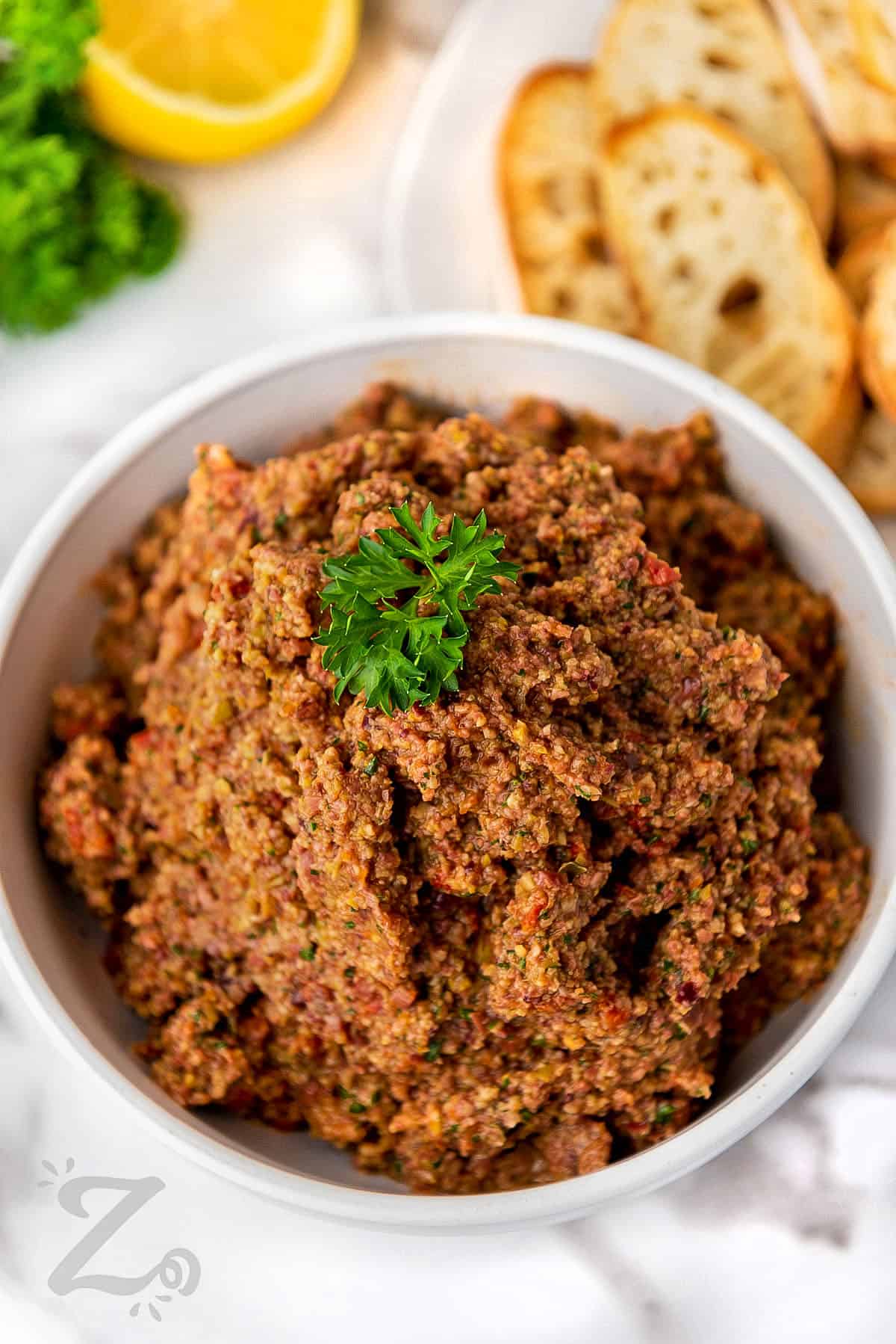 Olive Tapenade in a bowl with fresh parsley